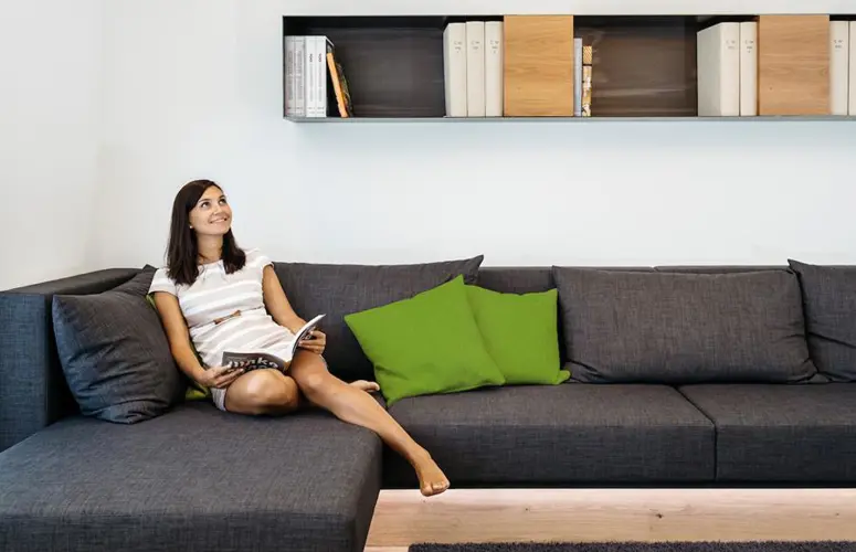 Happy woman on sofa in smart home